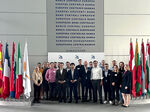Gruppenbild im Gebäude der EZB zwischen den Fahnen der Mitgliedsstaaten der Europäischen Union