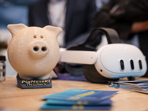 Zwei Demonstratoren, links eine Schweinchen, rechts eine VR Brille